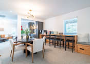 Thumbnail 31 of 44 - a living room with a dining room table and chairs and a kitchen with a counter