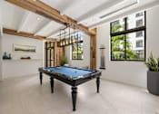 Thumbnail 12 of 63 - A pool table in a room with a wooden beam ceiling.