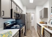Thumbnail 6 of 22 - a kitchen with white cabinets and stainless steel appliances and a sink