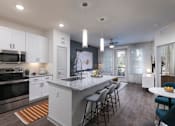 Thumbnail 4 of 47 - A modern kitchen with white cabinets and a large island.