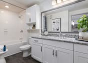 Thumbnail 15 of 47 - A white bathroom with a toilet, sink, and mirror.