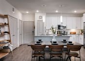Thumbnail 7 of 47 - A modern kitchen with a dining table set for two.