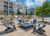 Thumbnail 13 of 28 - an outdoor patio area with tables and chairs and an apartment building