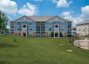 Thumbnail 27 of 28 - an apartment building with a yard and a batting cage