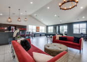 Thumbnail 19 of 28 - a living room with couches and chairs and a kitchen with a bar and tables
