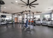 Thumbnail 15 of 28 - spacious gym with cardio equipment and windows at the district flats apartments