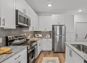 Thumbnail 2 of 47 - a kitchen with white cabinets and stainless steel appliances