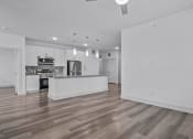 Thumbnail 45 of 47 - an empty living room and kitchen with white walls and wood floors
