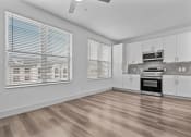 Thumbnail 29 of 47 - an empty kitchen with white cabinets and a large window