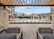 Thumbnail 7 of 47 - a pool with lounge chairs and a building with a pool