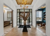 Thumbnail 13 of 47 - a lobby with a large plant in a vase and a glass door