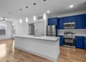 Thumbnail 33 of 47 - an empty kitchen with blue cabinets and a white counter top