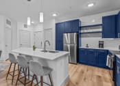 Thumbnail 46 of 47 - a kitchen with blue cabinets and a white counter top and a stainless steel refrigerator
