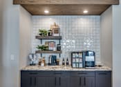 Thumbnail 6 of 24 - A kitchen with a marble countertop and a wooden shelf above it.