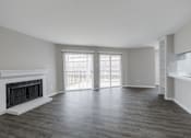 Thumbnail 25 of 61 - A spacious living room with a fireplace and sliding glass doors.