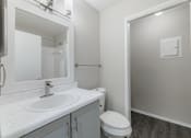 Thumbnail 39 of 61 - A white bathroom with a toilet, sink, and mirror.