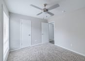 Thumbnail 42 of 61 - A room with a ceiling fan and three doors.