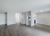 Thumbnail 29 of 61 - A room with wooden floors and white walls.