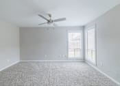 Thumbnail 38 of 61 - A room with a ceiling fan and carpeted floor.