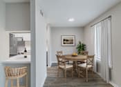 Thumbnail 2 of 29 - A dining room with a wooden table and chairs.
