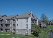 Thumbnail 2 of 21 - a view of an apartment complex with a pond in the foreground