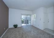 Thumbnail 7 of 21 - an empty living room with a door leading to a balcony