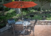 Thumbnail 15 of 21 - a patio with a table and chairs and an umbrella