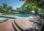 Thumbnail 13 of 21 - a swimming pool with lounge chairs and a hot tub in front of a building