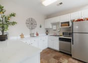 Thumbnail 32 of 35 - a kitchen with stainless steel appliances and white cabinets
