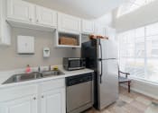 Thumbnail 30 of 35 - a kitchen with stainless steel appliances and a sink and refrigerator