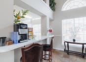 Thumbnail 27 of 35 - a kitchen with a coffee machine and a counter with chairs