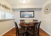 Thumbnail 7 of 35 - a dining room with a table and chairs and a mirror