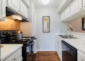 Thumbnail 3 of 35 - a kitchen with white cabinets and black appliances and a sink