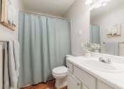 Thumbnail 12 of 32 - a bathroom with a shower and a sink and a toilet
