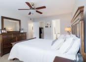 Thumbnail 10 of 32 - a bedroom with a large bed and a ceiling fan
