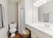 Thumbnail 14 of 32 - a bathroom with a toilet and a sink and a mirror