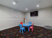 Thumbnail 27 of 32 - a play room with a table and chairs and a television