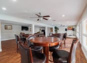 Thumbnail 21 of 32 - a dining room with a table and chairs and a ceiling fan