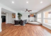 Thumbnail 22 of 32 - a living room with a ceiling fan and a drum kit