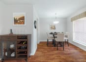 Thumbnail 4 of 32 - a dining room with a table and chairs and a kitchen with a large window