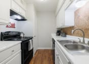 Thumbnail 1 of 32 - a kitchen with white cabinets and black appliances and a sink