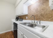 Thumbnail 2 of 32 - a kitchen with white cabinets and a stainless steel sink