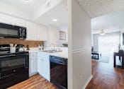 Thumbnail 2 of 54 - A kitchen with black appliances and white cabinets.
