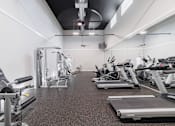 Thumbnail 25 of 54 - A gym with treadmills, elliptical machines, and other cardio equipment.
