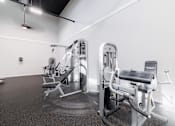 Thumbnail 28 of 54 - A gym with a row of exercise machines.