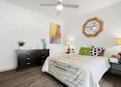 Thumbnail 27 of 43 - A bedroom with a bed, dresser, and ceiling fan.