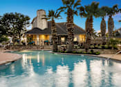 Thumbnail 34 of 43 - A house with a pool surrounded by palm trees.