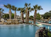 Thumbnail 35 of 43 - A pool surrounded by palm trees and a waterfall.