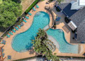 Thumbnail 37 of 43 - An aerial view of a swimming pool surrounded by palm trees and lounge chairs.