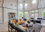 Thumbnail 13 of 21 - A large room with a couch, chairs, and a table.